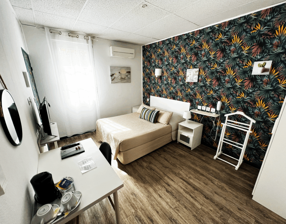 chambre confort hôtel abelia montpellier avec bureau et décoration tropicale