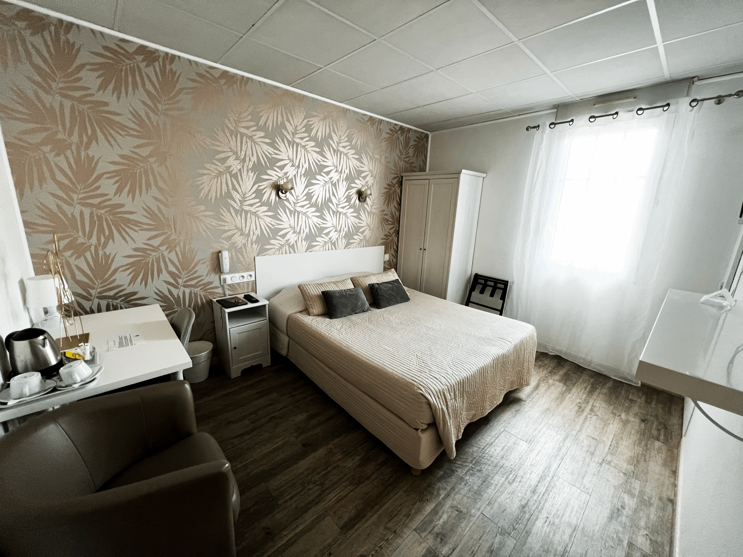 chambre queen hôtel abelia montpellier avec lit double et décoration beige