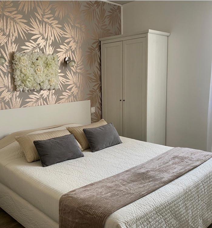 chambre queen hôtel abelia montpellier avec lit double et décoration beige doré
