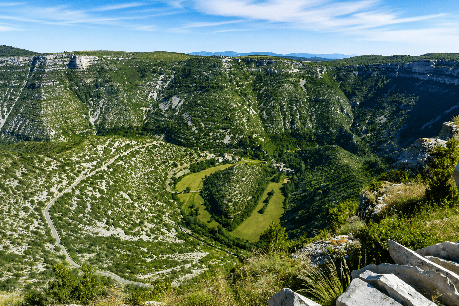 Vue panoramique du Cirque de Navacelles, site naturel classé du Grand Site de France, avec ses falaises calcaires et sa vallée verdoyante dans l'Hérault.